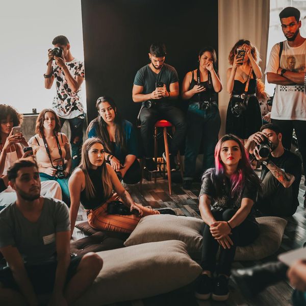 A group of diverse people practicing mindful movements in a bright studio.